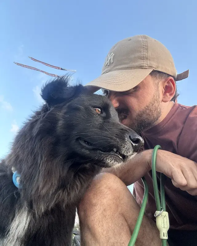 Flo wearing a cap, touching noses with his dog Pookie